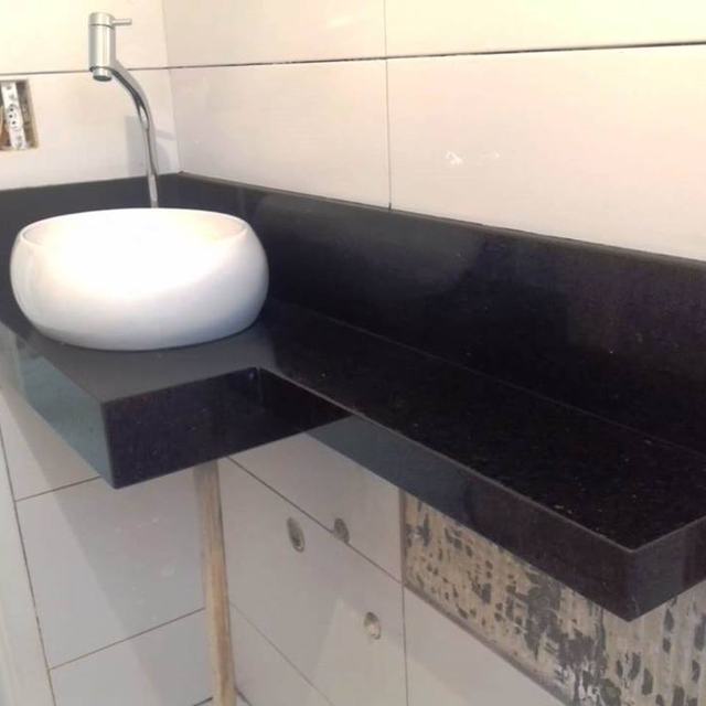 Lavatório em granito preto com cuba de apoio branca e rodapia